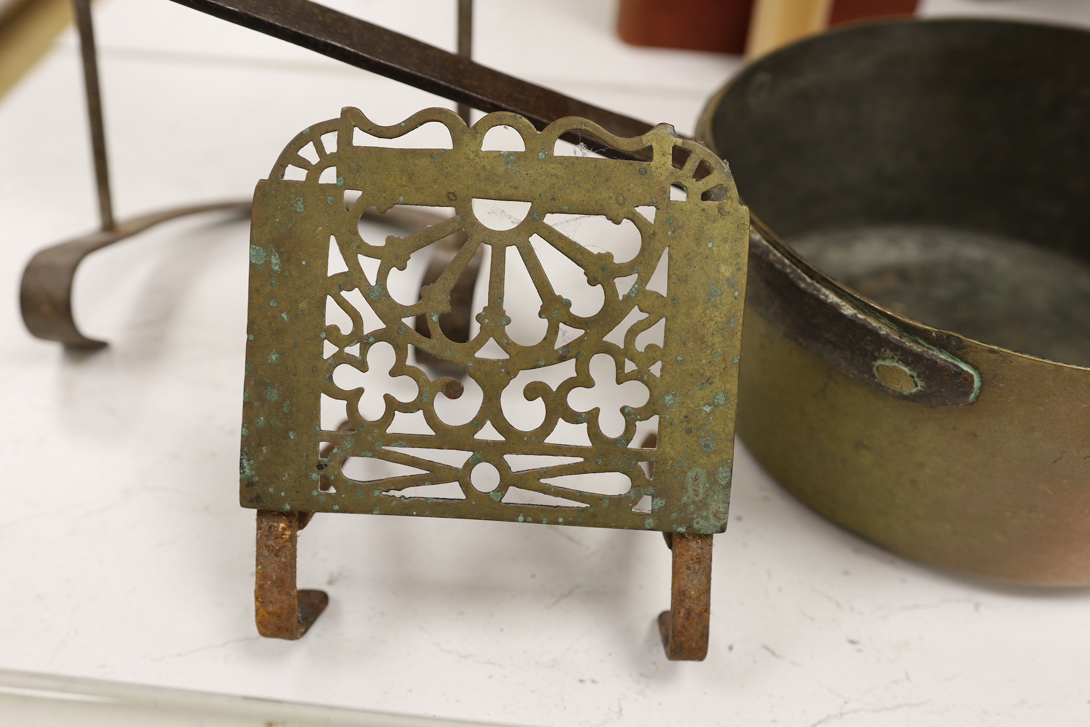 Two brass grate trivets, a crystal and brass towel rail and a 19th century copper pot